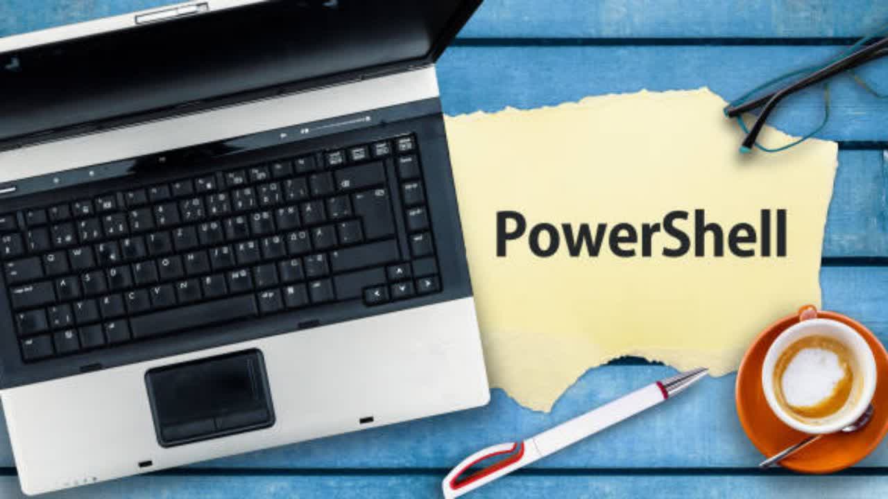 لوپتوب و پرینتر PowerShell روی میز آبی.